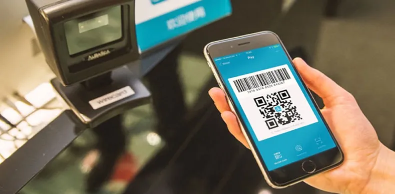 Smartphone displaying QR code for contactless payment at a retail checkout.
